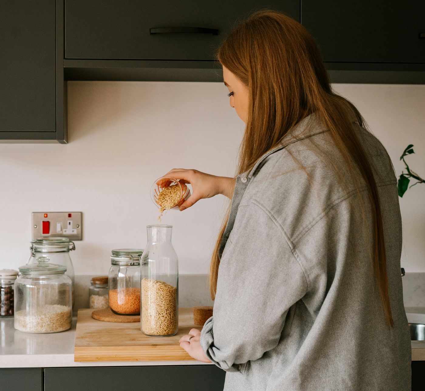 Someone at a kitchen counter filling jars, unhurried